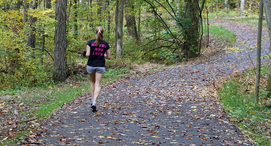 A female student running on the Allegheny River Valley Trail